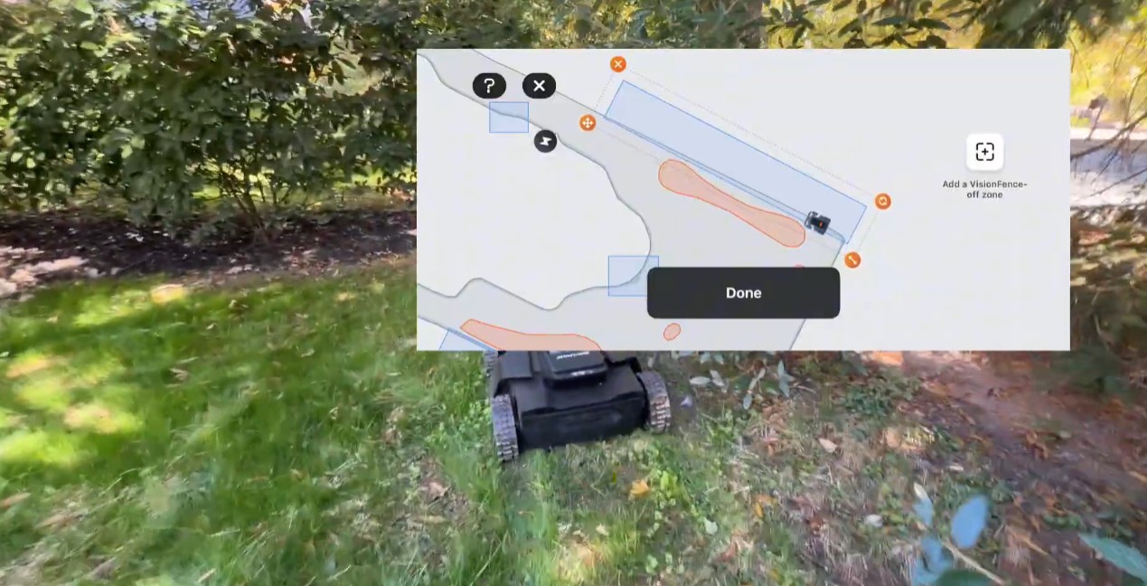 The Navimow app's map editor drawing a VisionFence-off zone along a mapped lawn edge, shown over a live view of the lawn and the mower