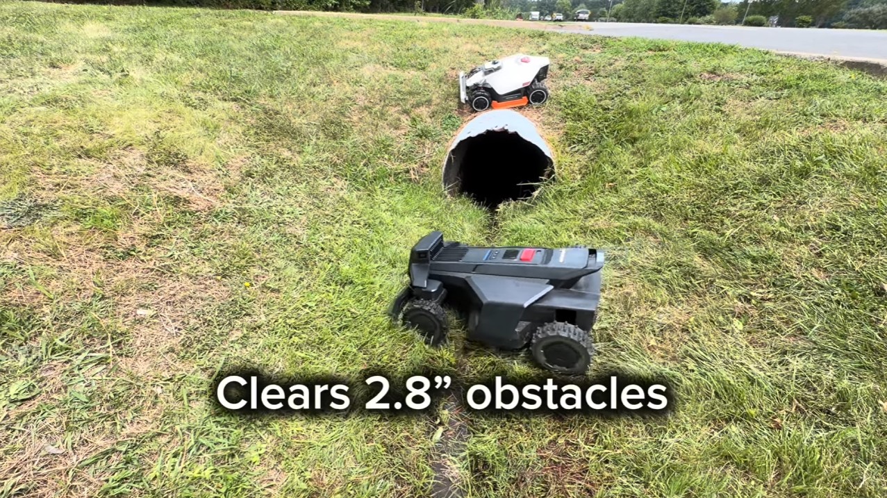 A Segway Navimow X4 clearing a 2.8-inch obstacle on rough ground
