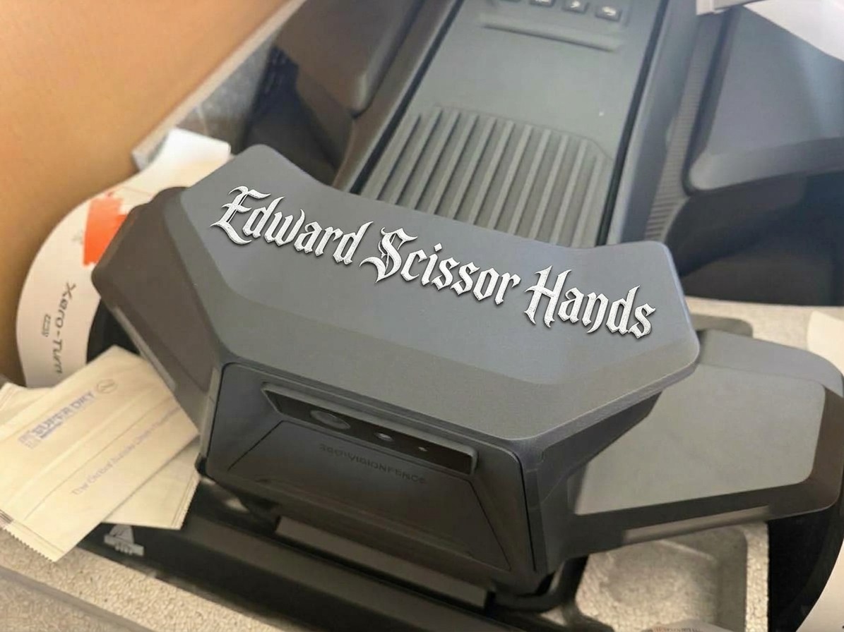 A custom Navimow nameplate reading “Edward Scissor Hands” in gothic lettering on the X4's decorative camera housing, in the box